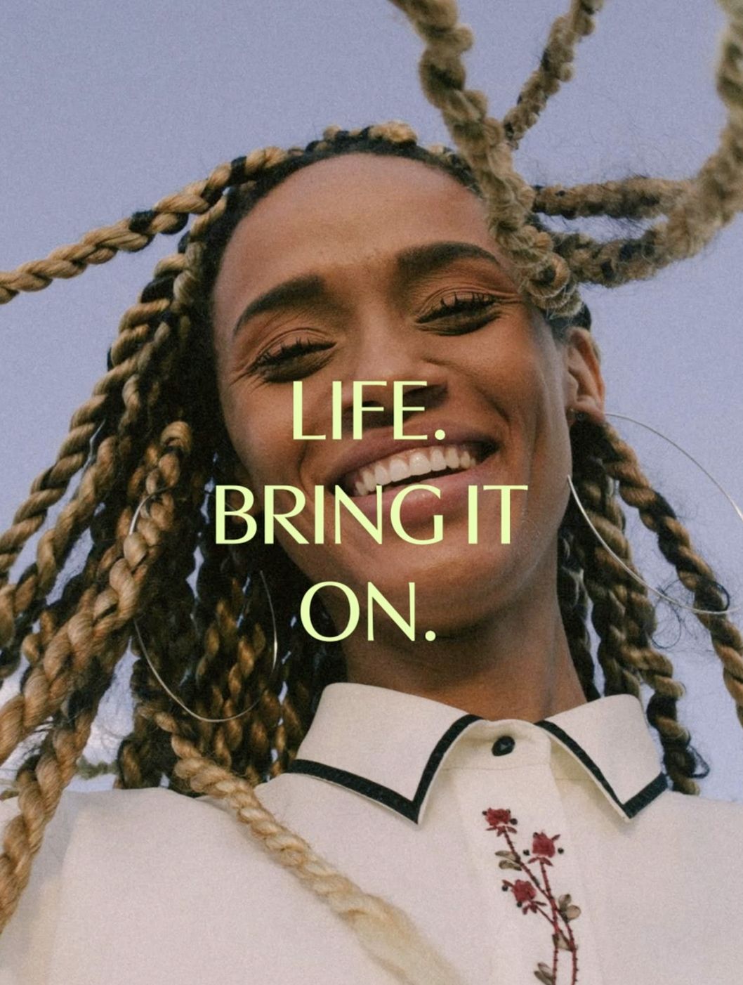 Smiling woman with braided hair under Great Earth's slogan "Life. Bring it on."