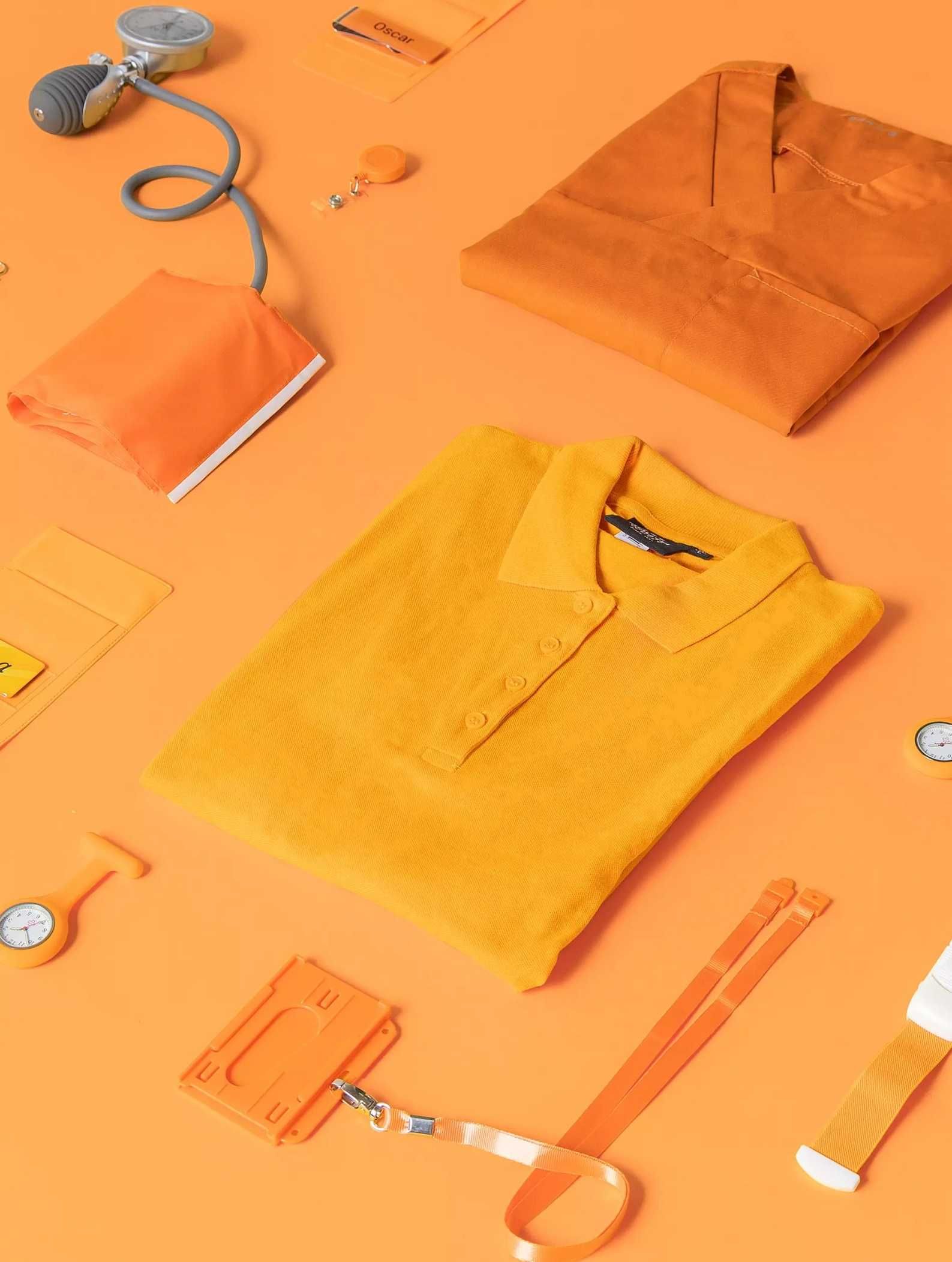 Orange and yellow healthcare tops, a blood pressure cuff and name badges on an orange background