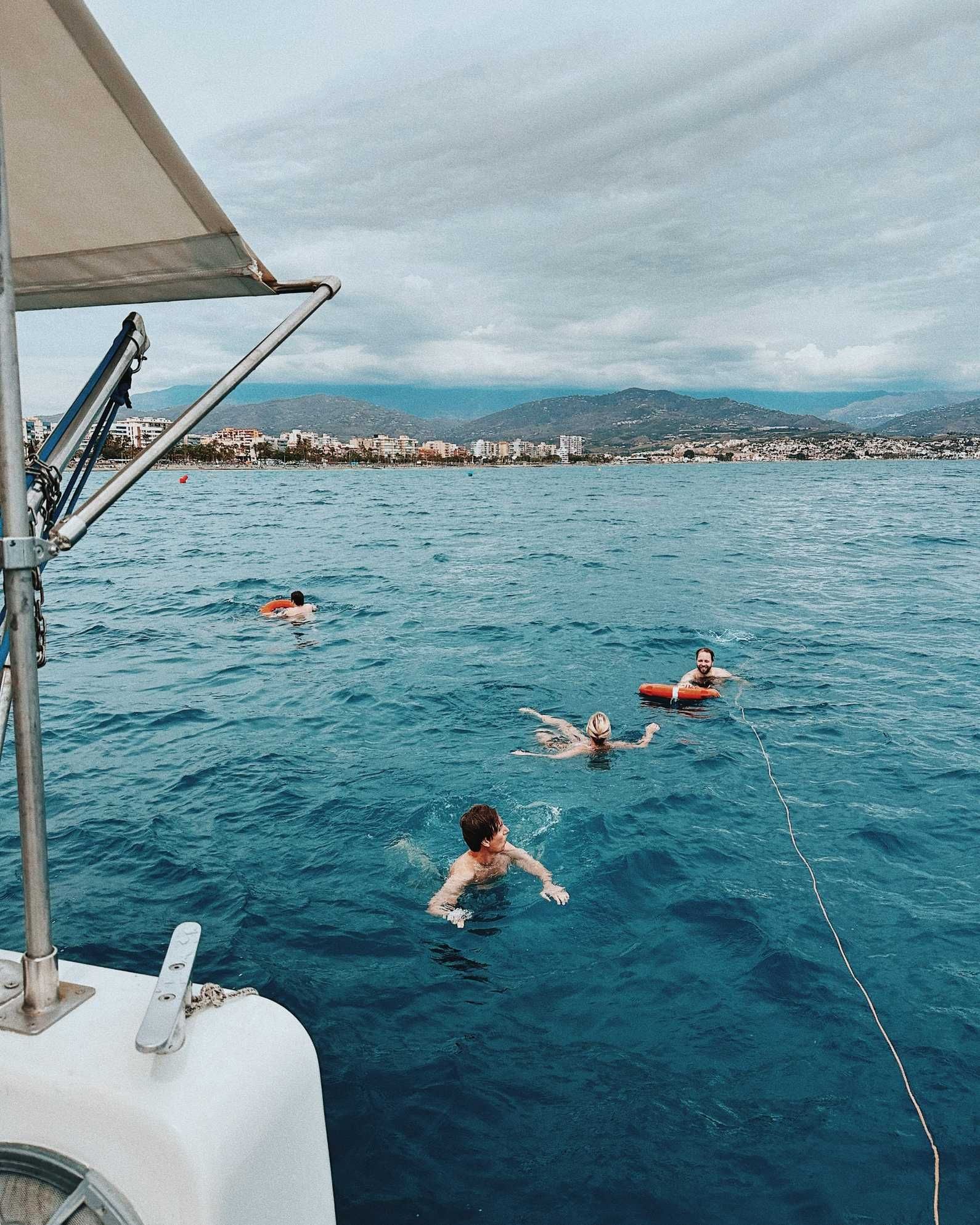 Kollegor som badar i havet från en båt