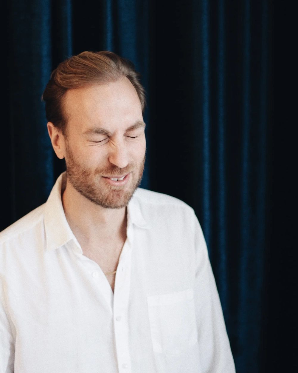 Johan som skrattar med stängda ögon